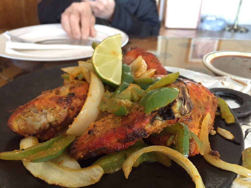 Grilled chicken platter with lime garnish and vegetables.
