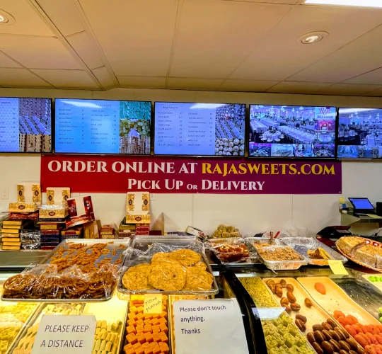 Bakery counter with a sign reading order online at Rajasweets.