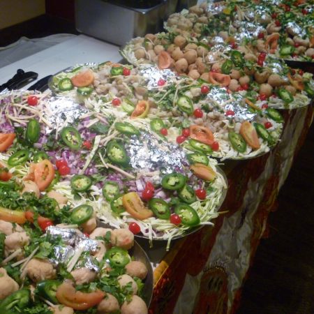 Table layout of catered food items at an indoor party.