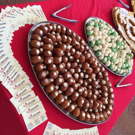 Large platter filled with dark brown sweets and green treats.